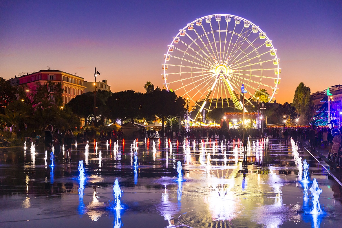 Une photo de nuit, avec une grande roue illuminée dans le centre de Nice.