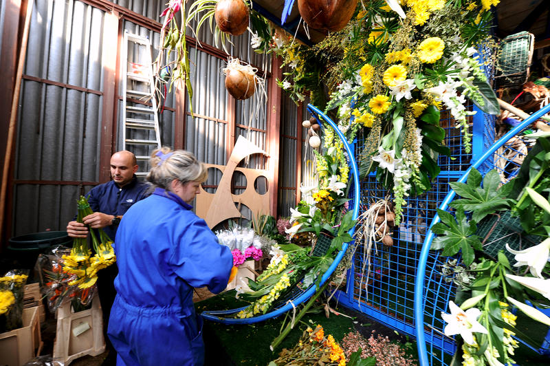 Fleuristes s'afférant à la confection d'un char de Bataille de Fleurs à Nice