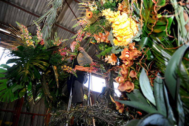 Fleuriste s'afférant à la confection d'un char de Bataille de Fleurs à Nice